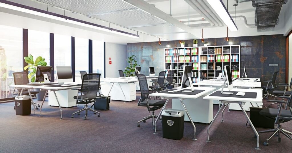A commercial fitout featuring white desks and exposed pipework
