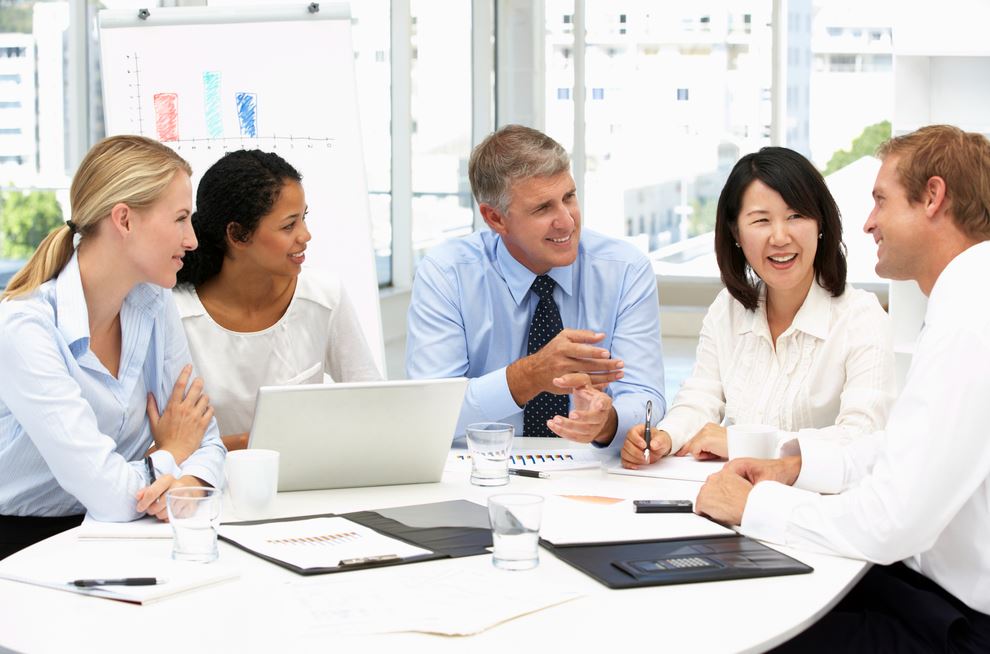 A team of people smailing and discussig how to use their office space to boost workplace morale