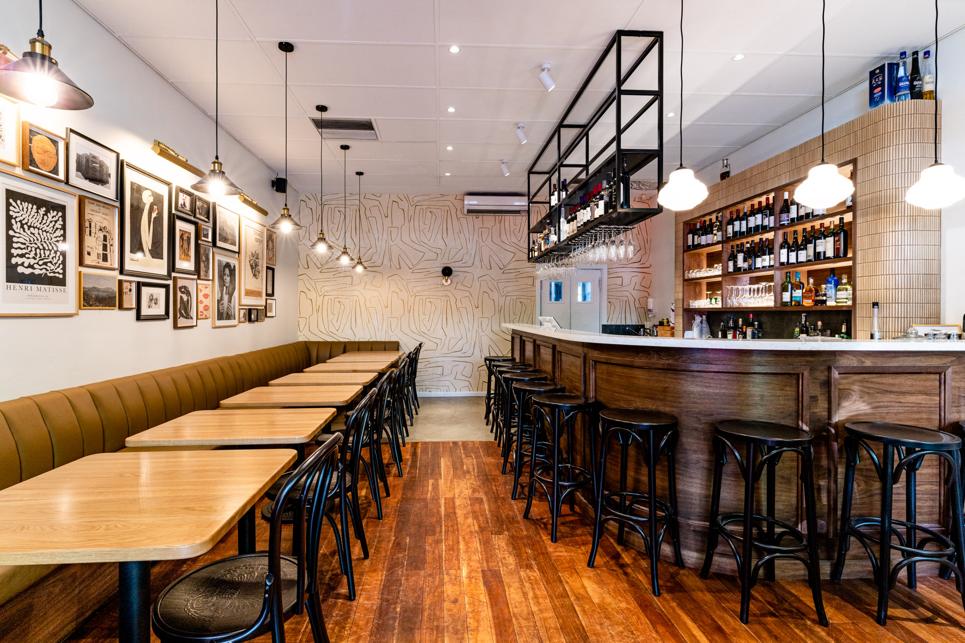restaurant fitout in Perth with a wooden bar, stools and and tables and timber flooring.