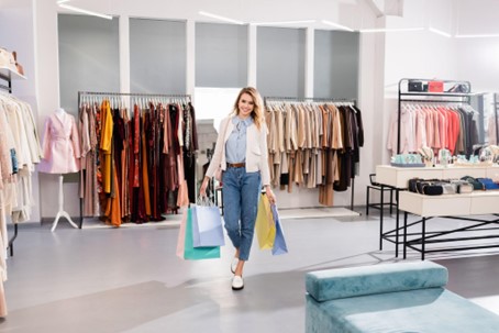 A woman carrying shopping bags and enjoying a sensory experience in a shop
