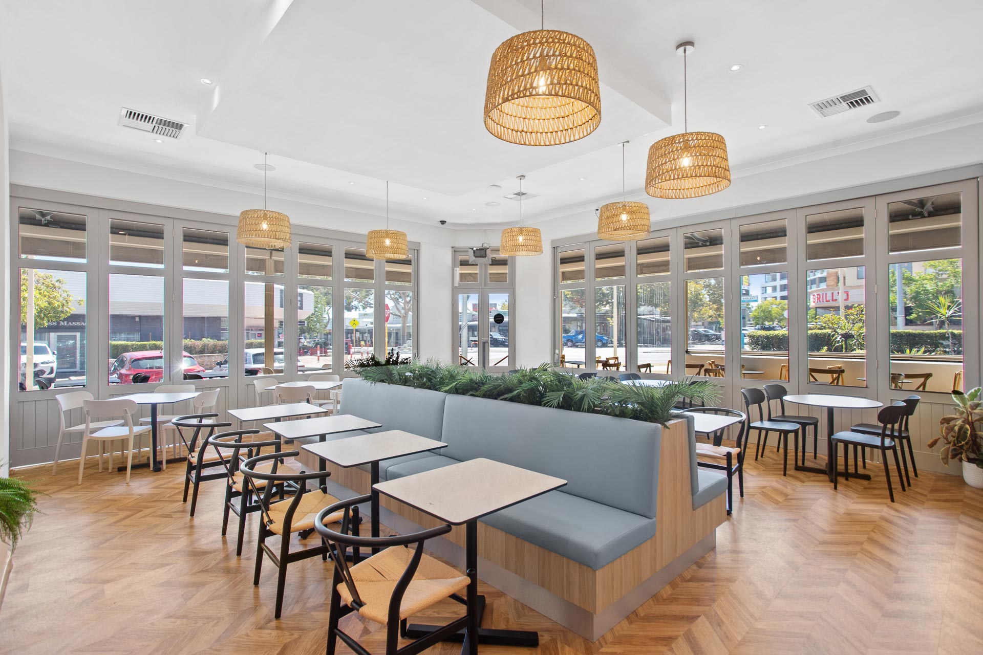 A cafe fitout in Perth, with natural timber flooring and plants.